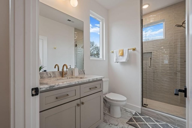 bathroom featuring toilet, marble finish floor, and a shower stall