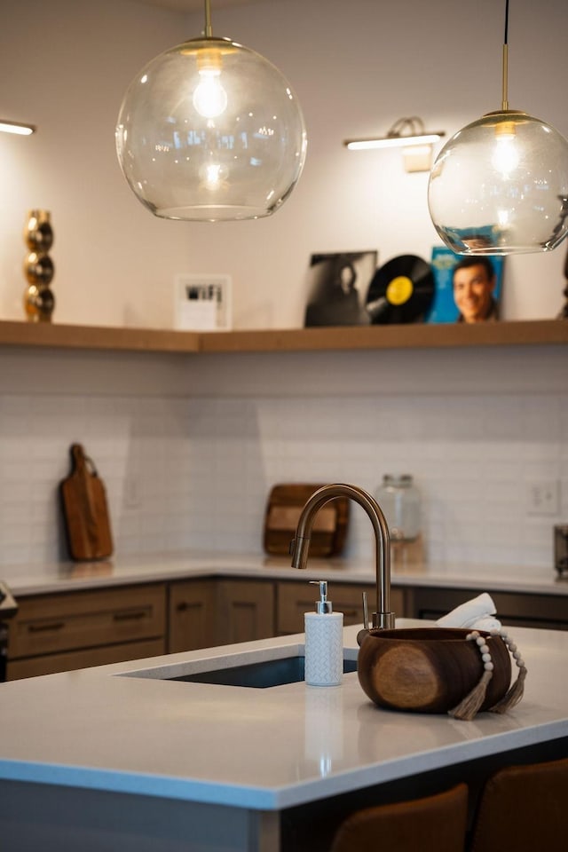 details with light countertops, a sink, decorative backsplash, and open shelves