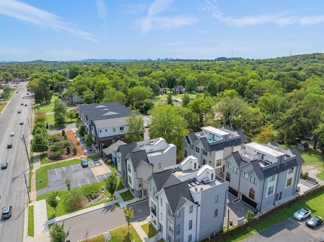 drone / aerial view featuring a forest view and a residential view