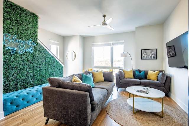 living area featuring ceiling fan, baseboards, and wood finished floors