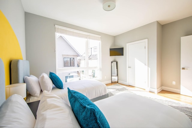 bedroom with baseboards and wood finished floors