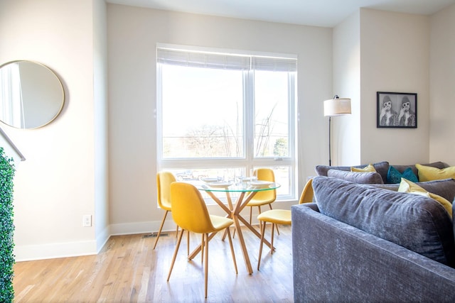 dining area with baseboards and wood finished floors