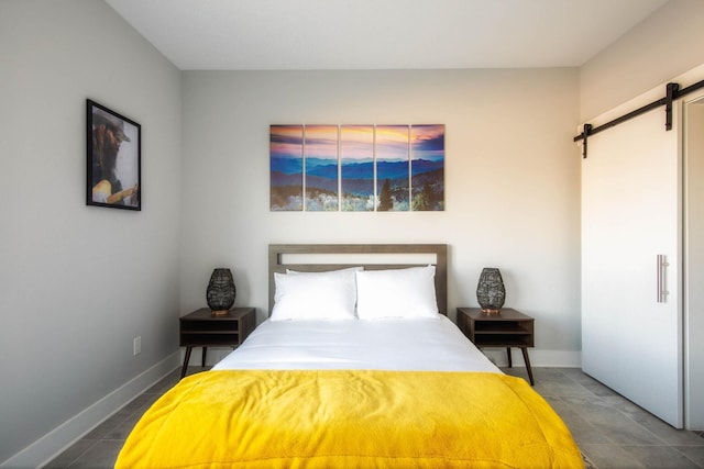 bedroom featuring a barn door and baseboards