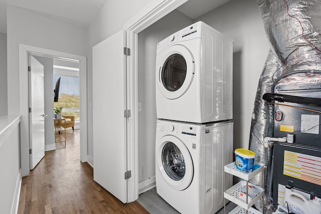 washroom featuring stacked washer and dryer, laundry area, and wood finished floors