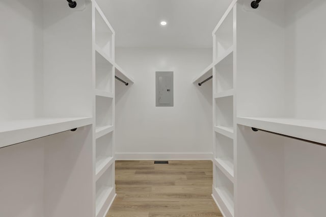 walk in closet featuring light wood-style flooring, electric panel, and visible vents