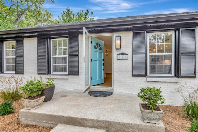 entrance to property featuring brick siding