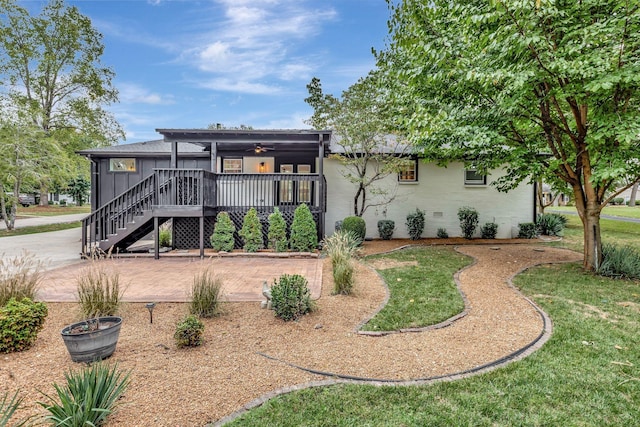 rear view of property featuring a yard, crawl space, ceiling fan, and stairway