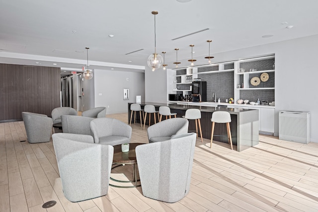 living area with light wood finished floors, wood walls, and recessed lighting