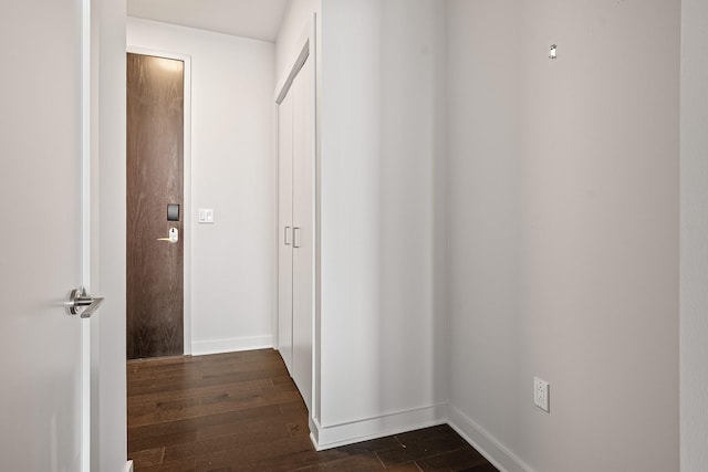 corridor with dark wood finished floors and baseboards