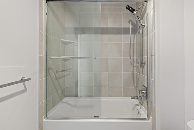 bathroom with bath / shower combo with glass door