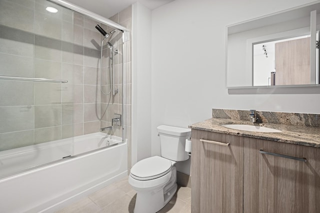 bathroom featuring combined bath / shower with glass door, vanity, toilet, and tile patterned floors