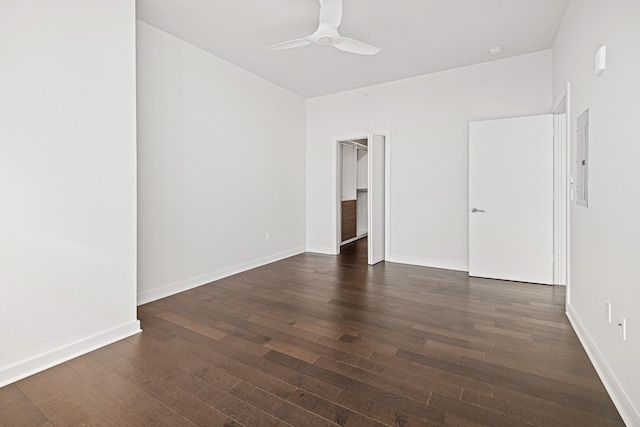 unfurnished bedroom featuring dark wood-type flooring, a ceiling fan, and baseboards