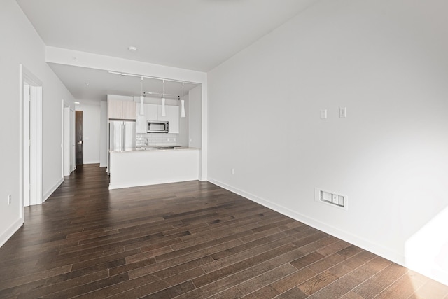 unfurnished living room featuring dark wood-style floors and baseboards