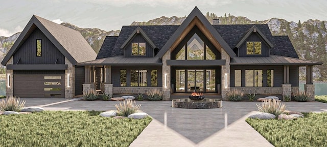 view of front of property featuring metal roof, driveway, a standing seam roof, and stone siding