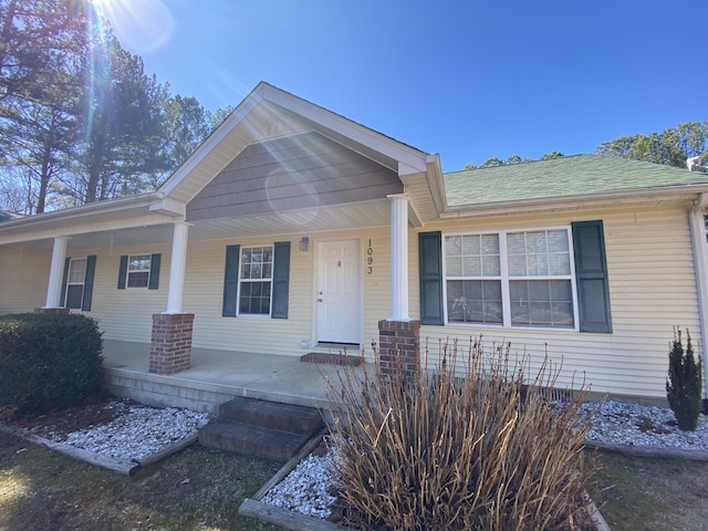 view of front of property with a porch and roof with shingles