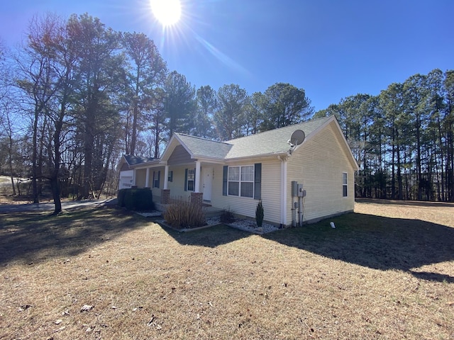 view of side of home featuring a porch and a yard