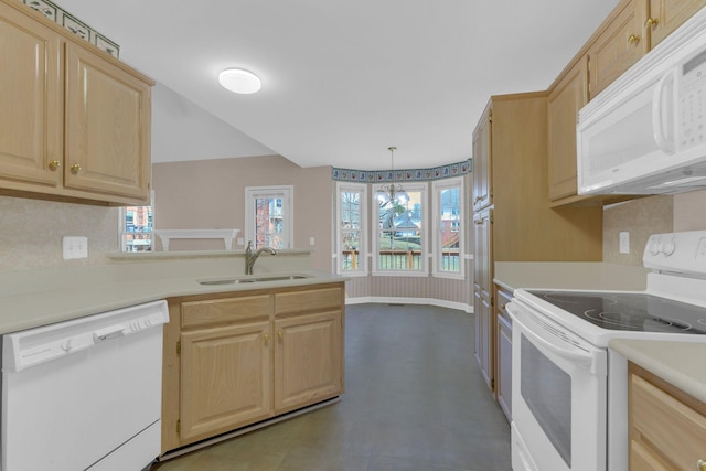 kitchen with a peninsula, white appliances, a sink, light countertops, and light brown cabinetry