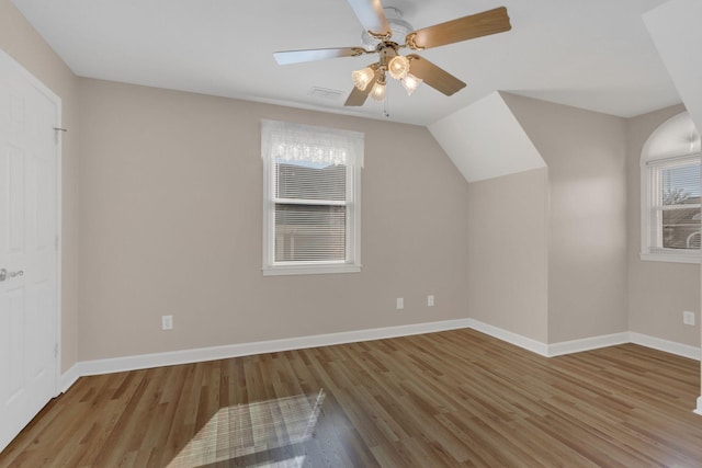 additional living space featuring visible vents, wood finished floors, a ceiling fan, and baseboards