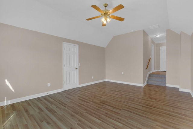 interior space featuring light wood-type flooring, lofted ceiling, baseboards, and a ceiling fan