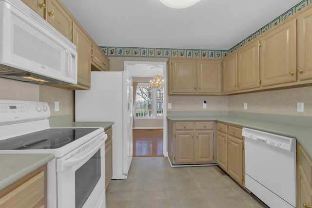 kitchen featuring white appliances, a chandelier, light countertops, and light brown cabinetry