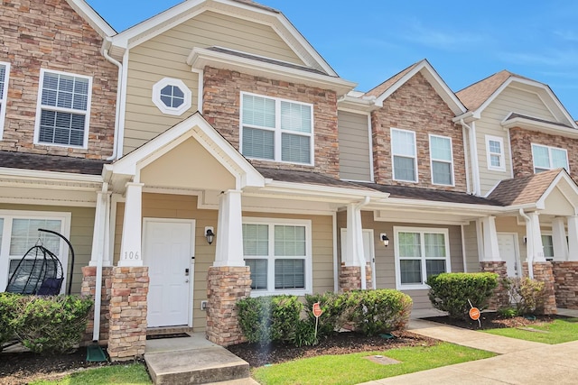 townhome / multi-family property featuring stone siding