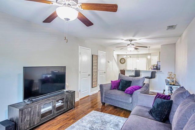 living area with visible vents, ceiling fan, baseboards, and wood finished floors