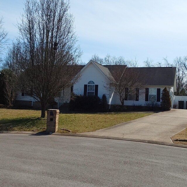 ranch-style home with driveway and a front lawn