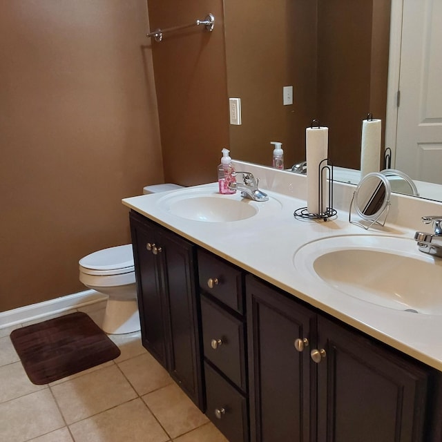 bathroom featuring double vanity, a sink, toilet, and tile patterned floors