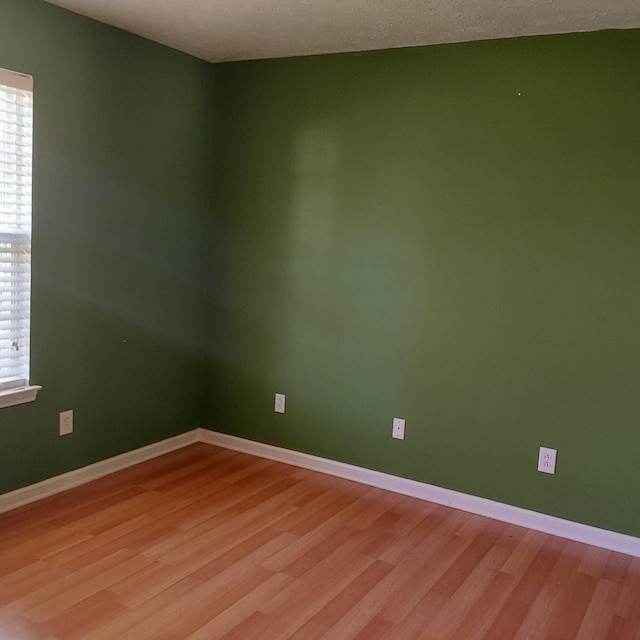 spare room with light wood-style flooring and baseboards