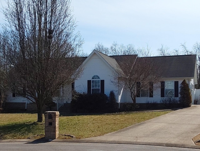 ranch-style house with roof with shingles and a front yard