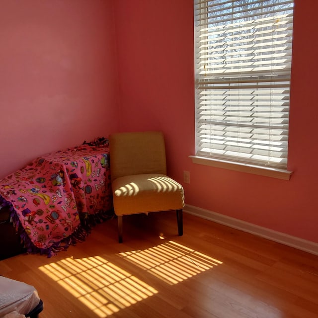 living area with baseboards and wood finished floors