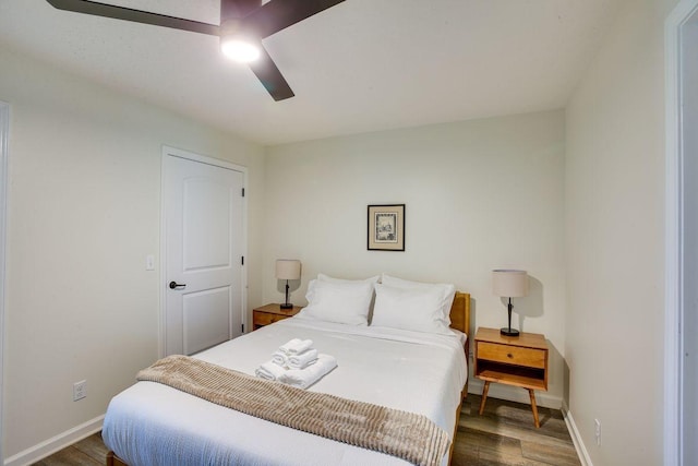 bedroom with ceiling fan, wood finished floors, and baseboards