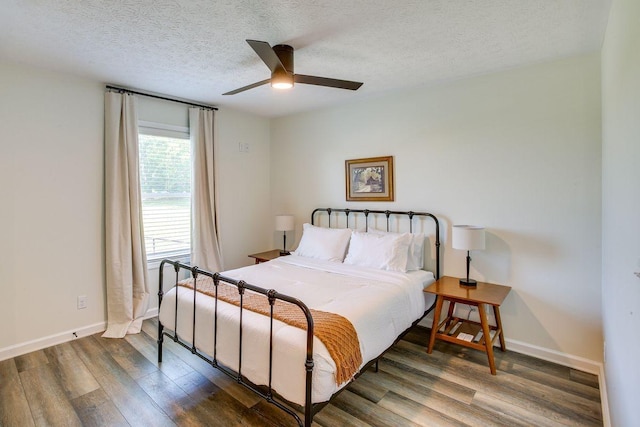 bedroom featuring a ceiling fan, a textured ceiling, baseboards, and wood finished floors