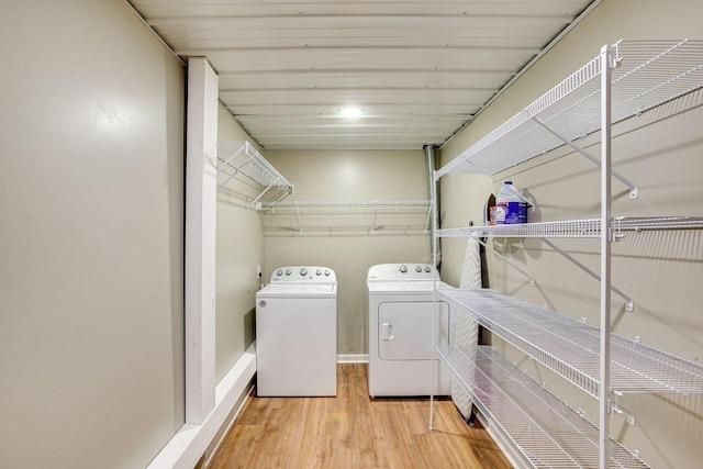 clothes washing area with laundry area, washer and clothes dryer, and wood finished floors