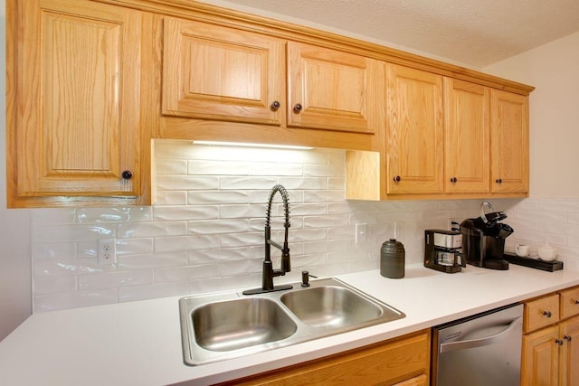 kitchen featuring light countertops, dishwasher, backsplash, and a sink