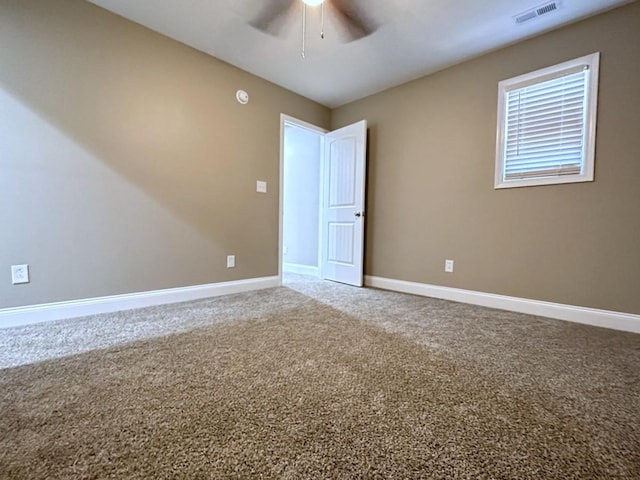 unfurnished room with ceiling fan, carpet flooring, visible vents, and baseboards