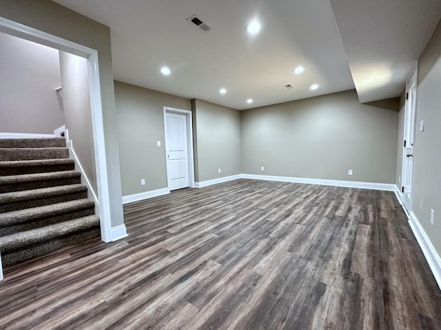 finished basement featuring baseboards, visible vents, dark wood finished floors, stairway, and recessed lighting