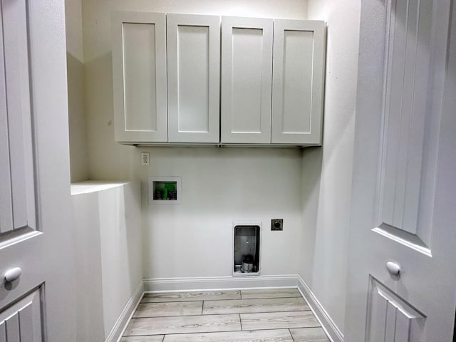 washroom featuring hookup for a washing machine, hookup for an electric dryer, baseboards, light wood-type flooring, and cabinet space