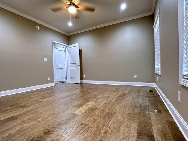 empty room featuring ornamental molding, dark wood finished floors, and baseboards