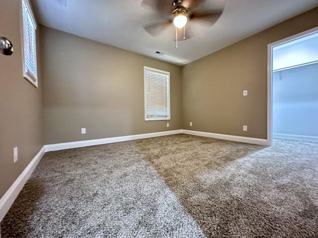 unfurnished room with carpet, baseboards, and a ceiling fan