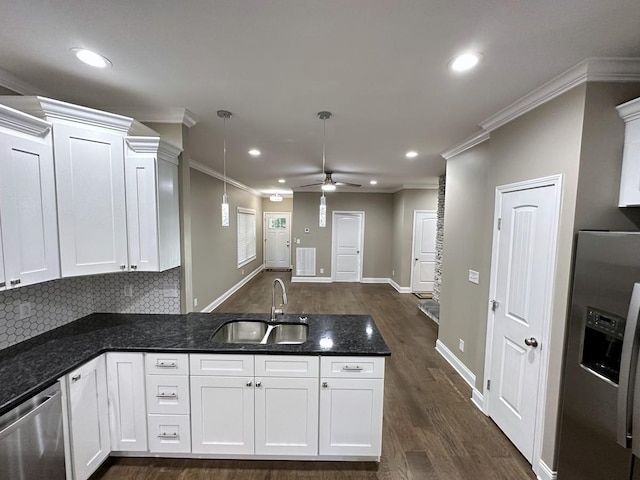 kitchen with a peninsula, stainless steel appliances, crown molding, white cabinetry, and a sink