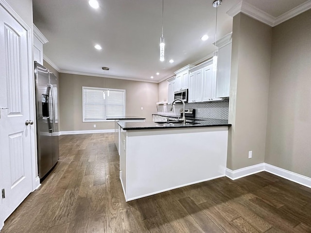 kitchen with dark wood-style floors, stainless steel appliances, dark countertops, and crown molding