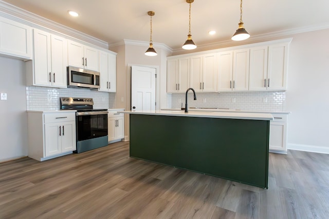 kitchen with stainless steel appliances, wood finished floors, white cabinetry, light countertops, and ornamental molding