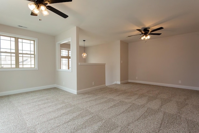 unfurnished room with carpet floors, baseboards, visible vents, and ceiling fan