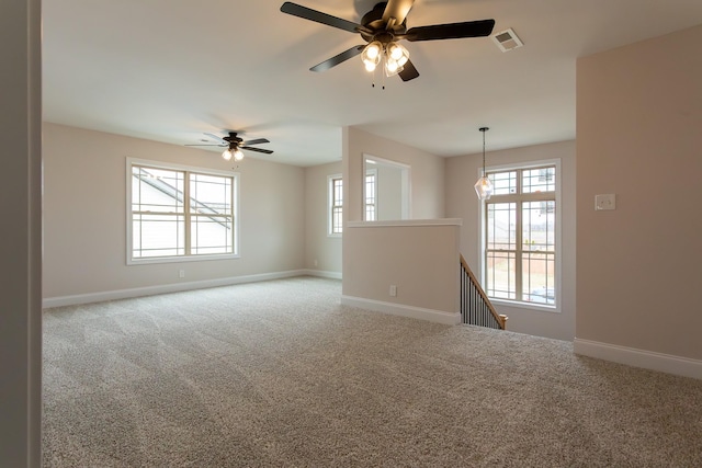 carpeted spare room featuring baseboards and visible vents