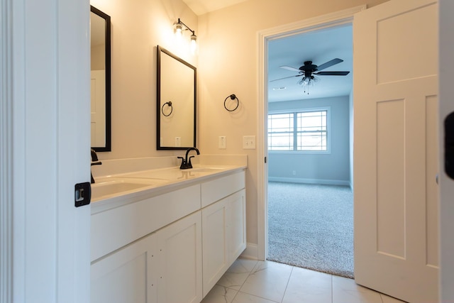 bathroom featuring double vanity, a sink, a ceiling fan, and baseboards