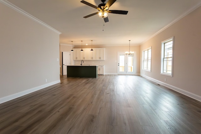 unfurnished living room with a sink, crown molding, baseboards, and dark wood-style flooring