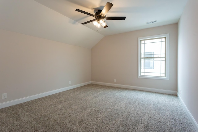 bonus room featuring lofted ceiling, light colored carpet, visible vents, a ceiling fan, and baseboards