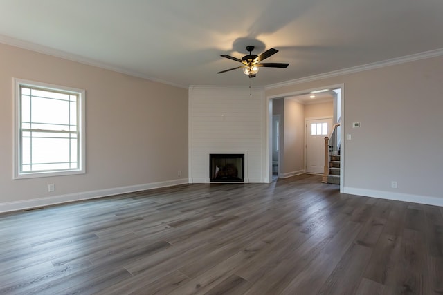 unfurnished living room featuring a large fireplace, baseboards, dark wood-style floors, stairway, and crown molding