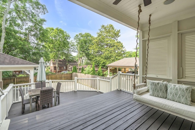 deck featuring outdoor dining area, fence, and ceiling fan